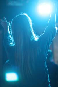 image of blue-backlit young lady praising.